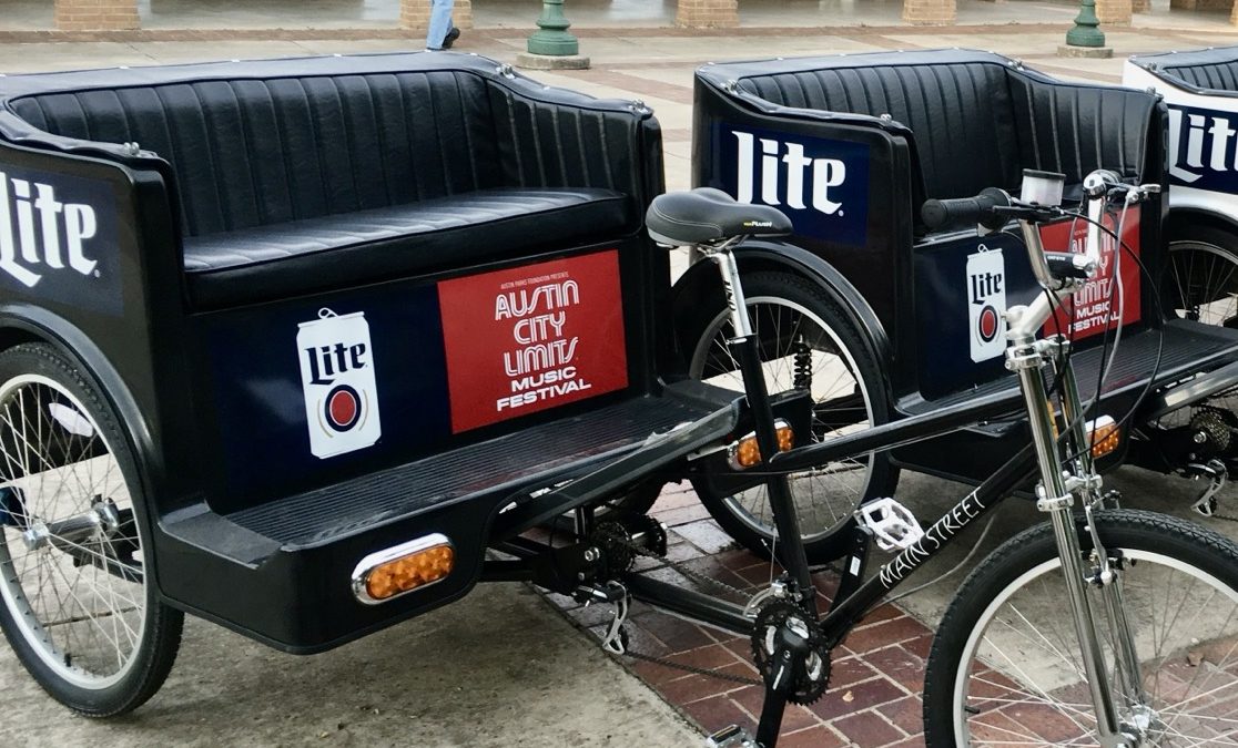 Pedicab carriages branded with Miller Lite and Austin City Limits Music Festival panels, staged before a festival day